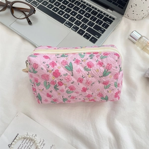 Close-up of pink quilted floral makeup bag with tulip pattern and zipper closure