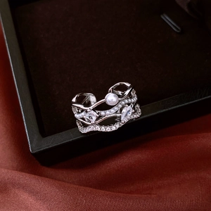 Détail d'une bague multicouche en argent avec perle sur soie et boîte à bijoux noire