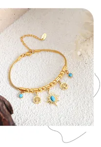 Dettaglio del bracciale serpente dorato boho con ciondolo sole e pietre turchesi
