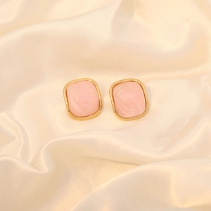 Elegant candy-colored pink square stud earrings with gold plating on cream satin
