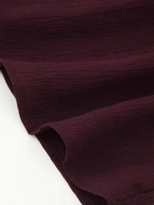 Detailed macro view of dark burgundy ethnic style fabric with fine horizontal texture