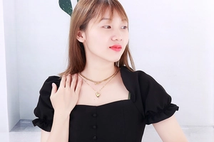 Detail of double-layer gold titanium steel necklace with heart pendant on neck