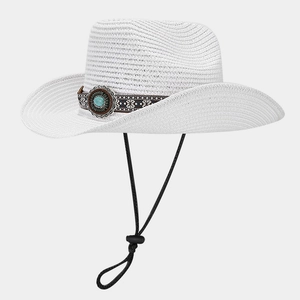 Detail of white straw cowboy hat featuring ethnic embroidery and turquoise stone ornament