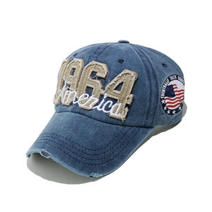 Detail of 1964 America embroidery on washed blue denim baseball cap with vintage distressed look