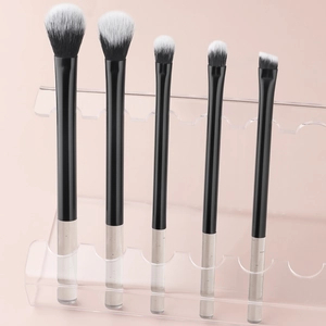 Detailed view of 5-piece mini makeup brushes with crystal handles on pink stand