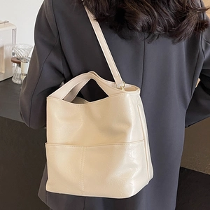 Minimalist cream white PU leather tote bag with shoulder strap and front pocket detail