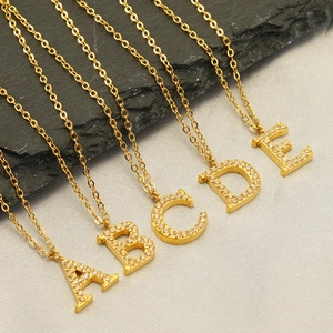 Detailed view of gold stainless steel O-chains with crystal-encrusted A to E initial pendants