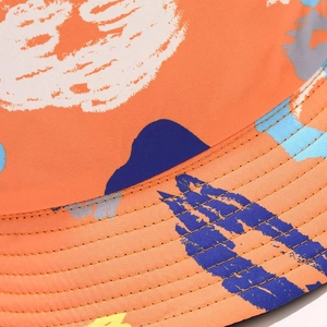 Detailed close-up of orange sun hat brim featuring reinforced stitching and colorful graffiti