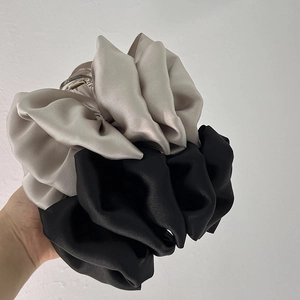 Detailed shot of elegant black and silver satin bow hair clips in hand