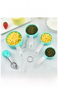 Detailed set of mint green measuring cups and spoons with stainless steel handles on marble