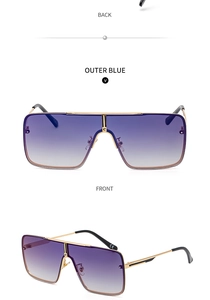 Detail view of large metal frame sunglasses with gradient blue lenses and C-shaped bridge