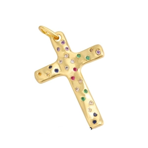Macro shot of gold cross pendant with colorful zircon stones and hammered metal texture