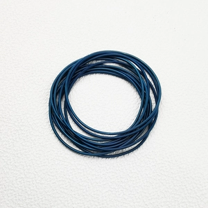 Detail of multi-layer navy blue spring wire bracelets with fine metallic spiral texture