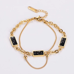 Close-up of golden double-layer chain bracelet with black rectangular rhinestones