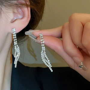 Detail shot of long silver tassel rhinestone earrings with sparkling pavé crystals