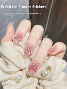 Macro shot of white 3D ice flower nail stickers with floral embossed texture on pink base