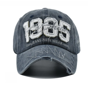 Detail of 1985 embroidery and distressed edges on washed cotton baseball cap