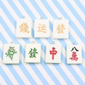 Detail view of 7 colorful mahjong tile charms with gold and red Chinese characters