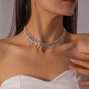 Detailed close-up of a vintage silver choker necklace with hollow patterns and small beads