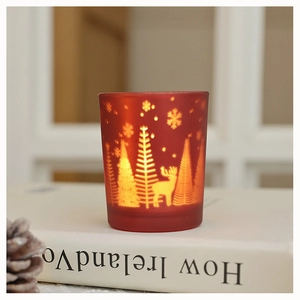 Detail of red frosted glass candle holder with reindeer and snowflake patterns