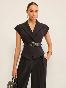 Combinaison pantalon noire sans manches avec blazer et ceinture à boucle dorée élégante