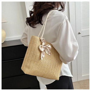 Détail du sac cabas en paille avec anses en coton et foulard décoratif en soie pour femme