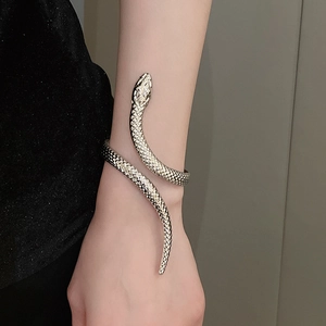 Detailed view of silver snake bangle with realistic scale texture on a woman's wrist