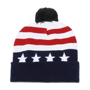 Close-up of USA flag knit beanie with red stripes, white stars and black faux fur pompom