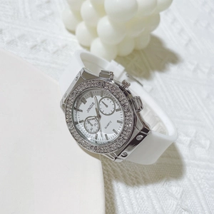 Detailed close-up of white quartz watch with rhinestone bezel and silicone strap