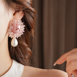 Macro side view of a large pink fabric rose earring with beads and a waterdrop pearl