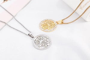 Detail of Hamsa Hand necklace pendants in gold and silver finish with crystal inlay