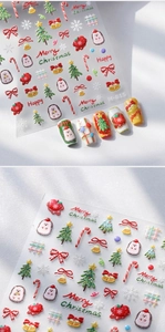 Macro shot of 3D embossed Christmas nail stickers with tree and snowflake patterns