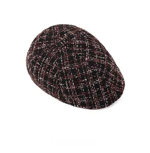 Top view detail of retro tweed check newsboy cap showing black and red woven texture