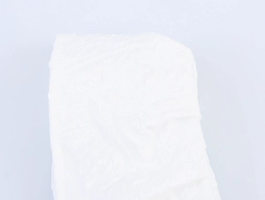 Close-up detail of white dress fabric showing the elegant floral embossed texture and material