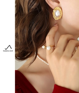 Detail of gold-plated stainless steel jewelry set with pearls on a model wearing velvet