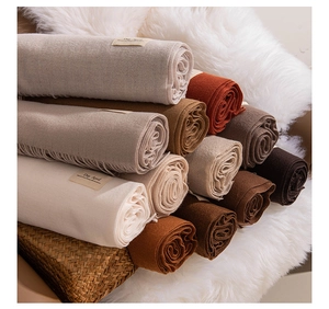 Detailed view of folded soft cashmere texture scarves in various earthy color tones