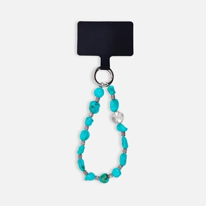 Detail of turquoise beaded phone strap with irregular stones and silver round charm