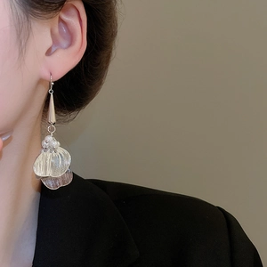 Detail of silver layered petal earrings with pearls and tassels on model