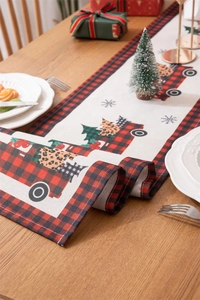 Detail of Christmas table runner with red plaid truck and leopard print tree on wood table