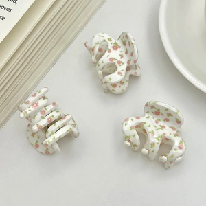 Floral hair claw clips with pink flowers and green leaves pattern on white background