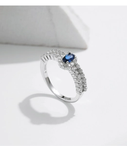 Macro shot of S925 sterling silver ring featuring an oval blue gem and side stones