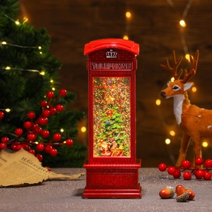 Close-up of red Christmas telephone booth lamp with Santa and floating snow glitter