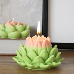 Detail of lit gradient pink lotus candle showing intricate petal textures and cotton wick