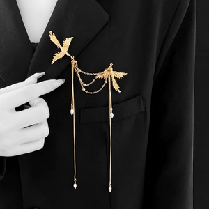 Elegant gold phoenix brooch with chain tassels and pearls on a black suit jacket