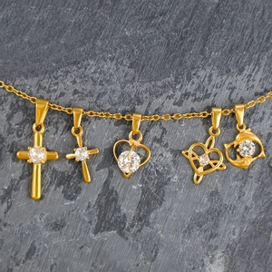 Close-up of five 24K gold plated titanium steel pendants with clear cubic zirconia stones