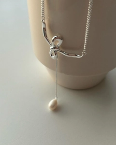Detailed view of sterling silver bow knot pendant with a natural freshwater pearl drop