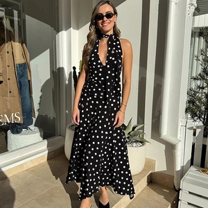 Detail of elegant black and white polka dot halter maxi dress with matching neck scarf