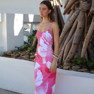 Detail of pink floral maxi dress featuring a high-slit hem and vibrant summer flower print