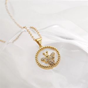 Detailaufnahme einer goldenen runden Halskette mit mikroverzierten Zirkonia-Bienenmotiv