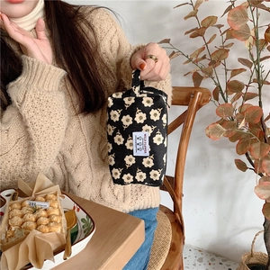Détail de la trousse de maquillage en velours côtelé à fleurs avec étiquette Wild Flower